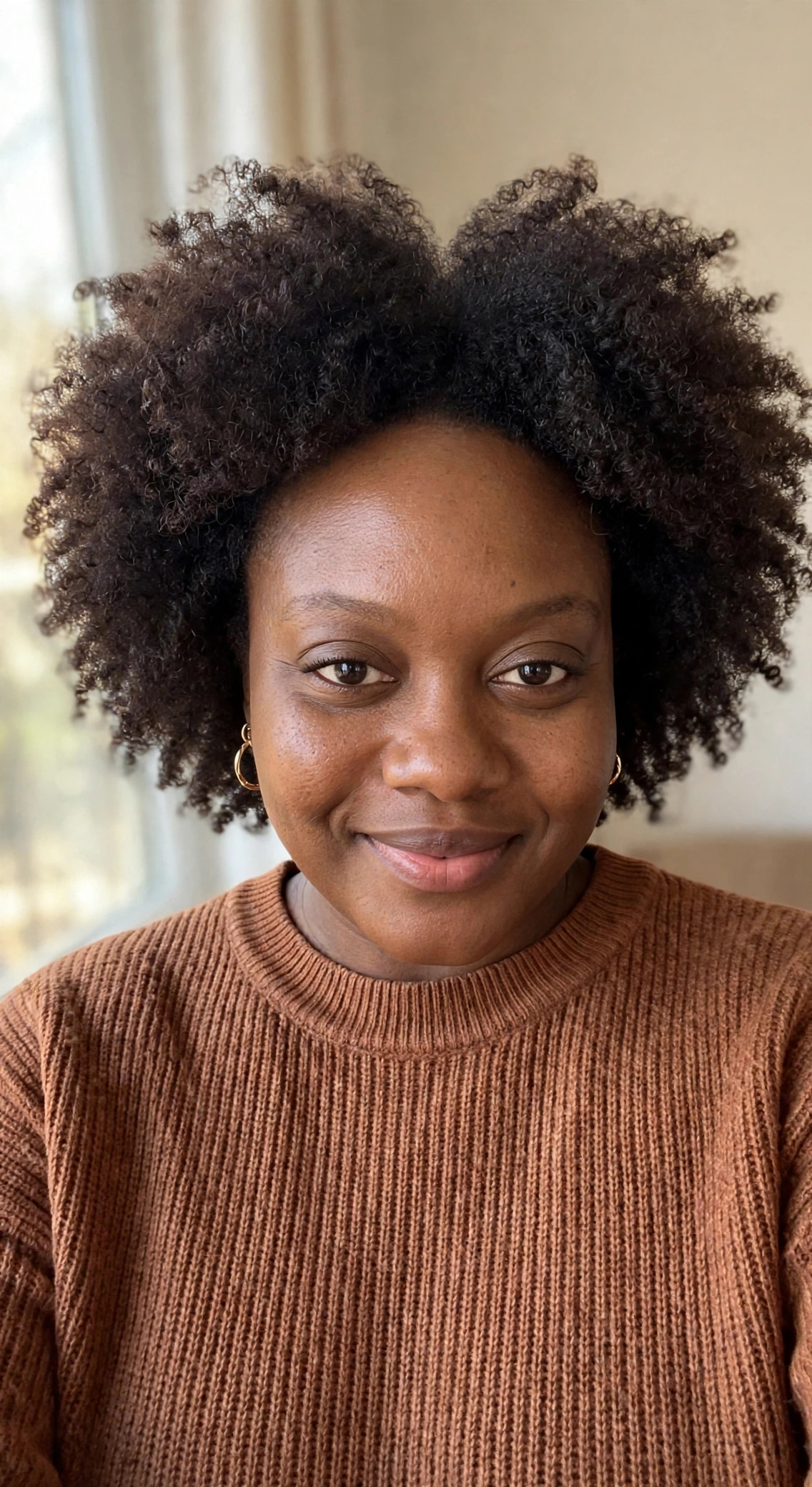 Joneal, founder of The Coily Company, wearing her natural coily hair out
